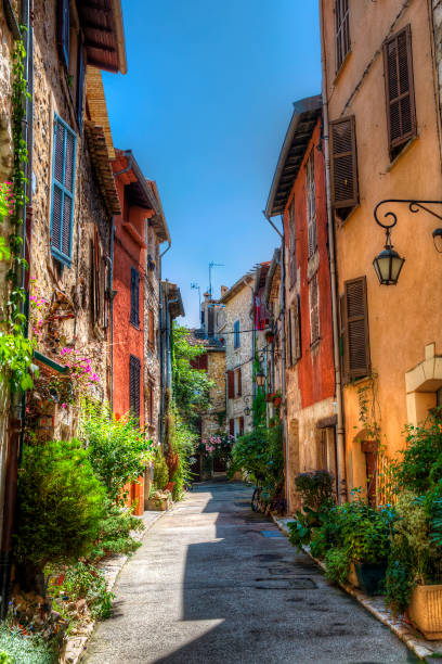 Ruelle en pente du vieux village de Vence, aux façades colorées et aux plantes en pot