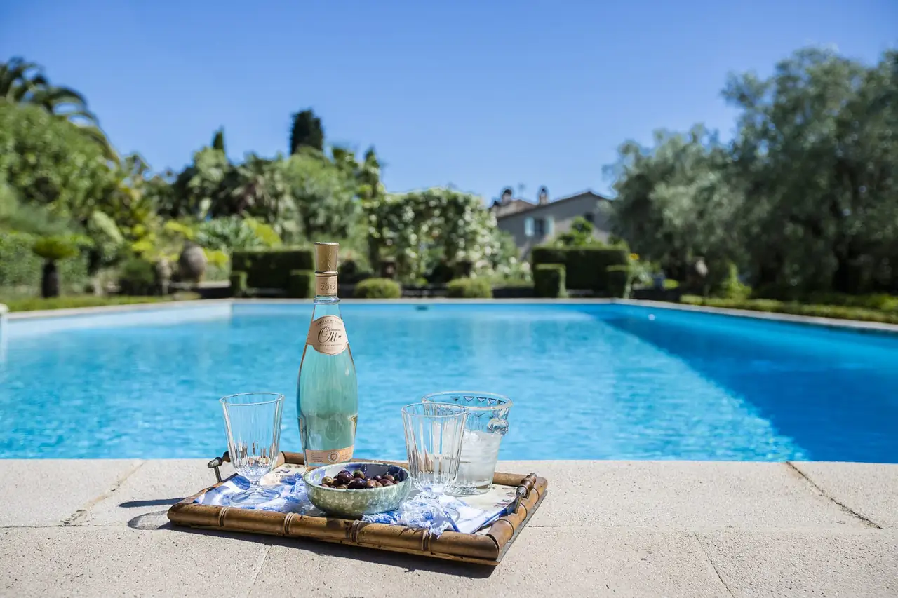 A tray of refreshments by a pool, with a Mediterranean garden beyond