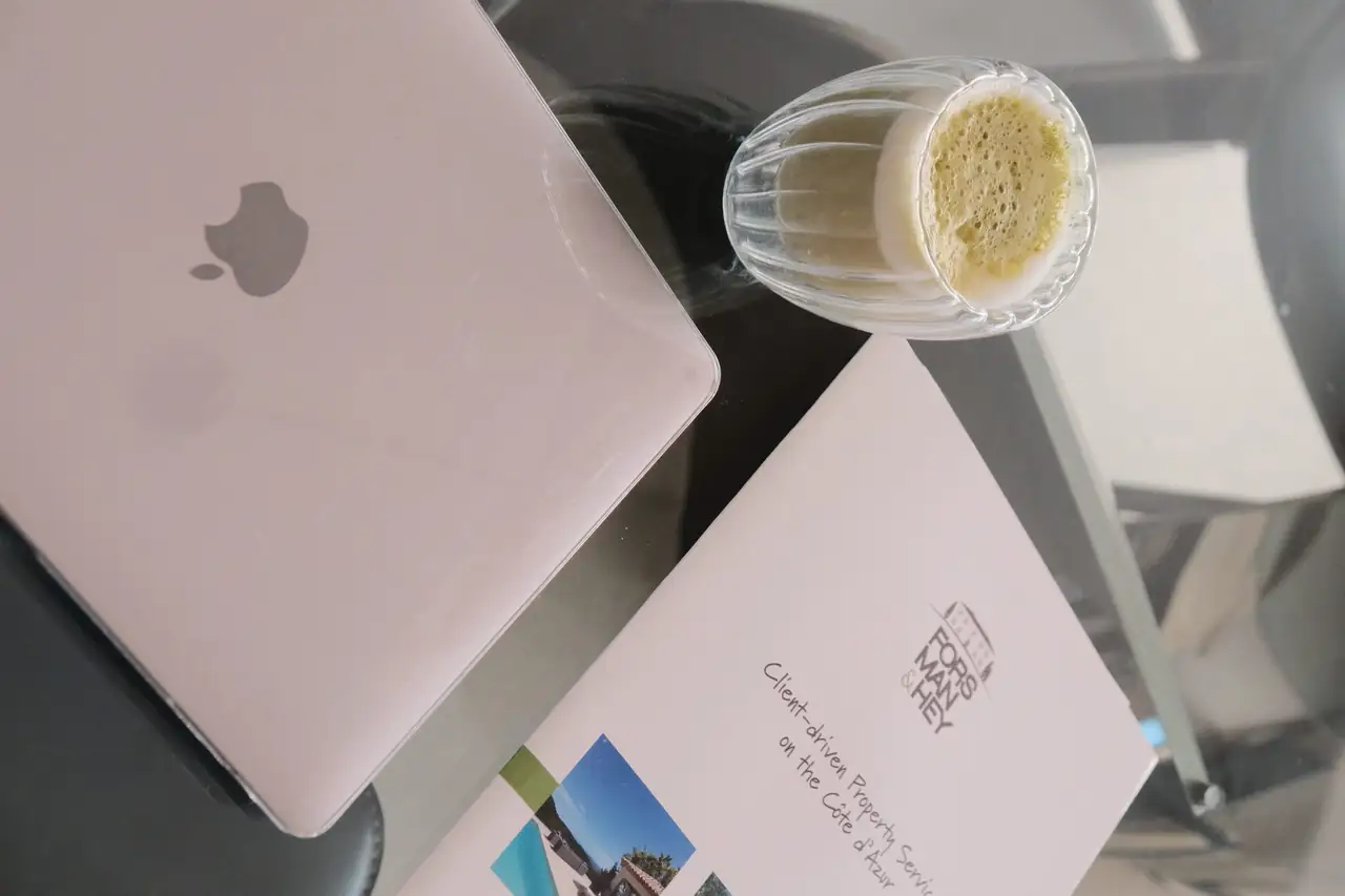 The agency brochure beside a laptop on a glass table
