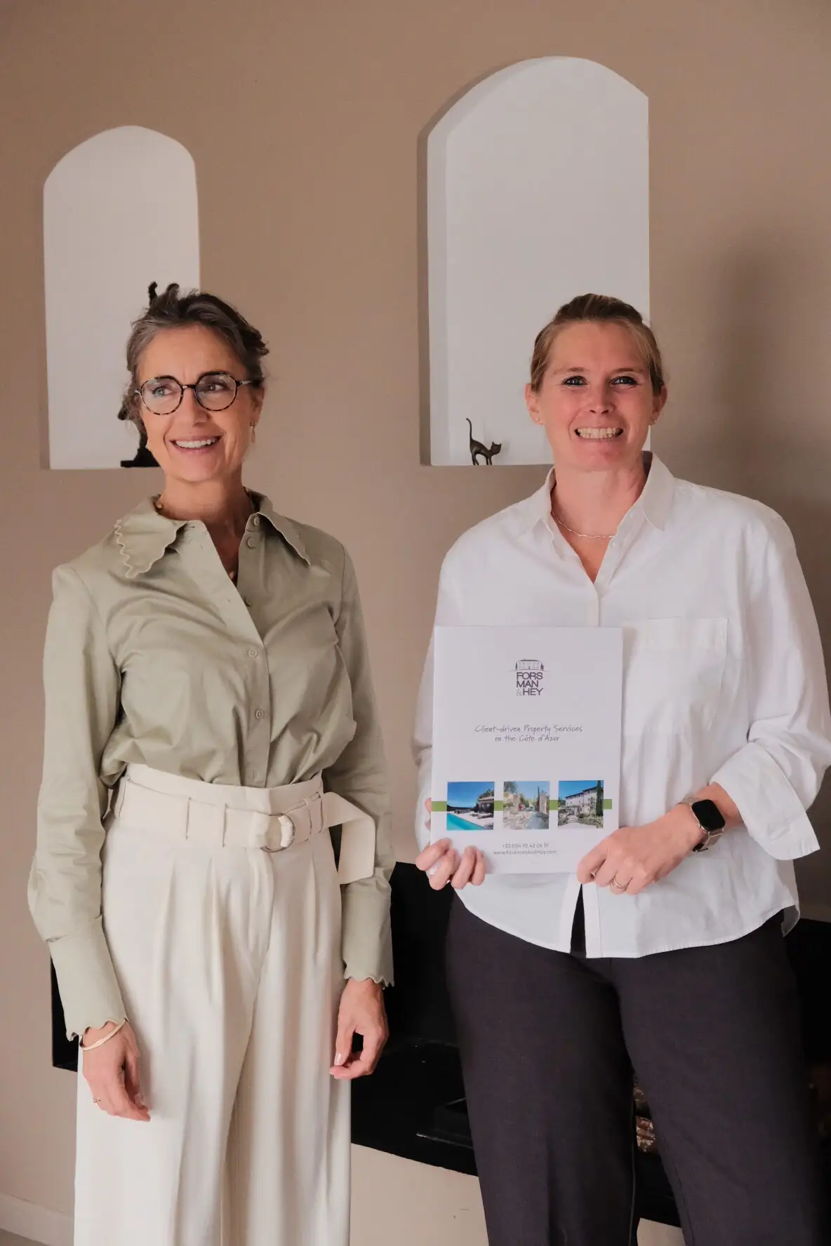 The Forsman & Hey team side by side, holding the presentation brochure